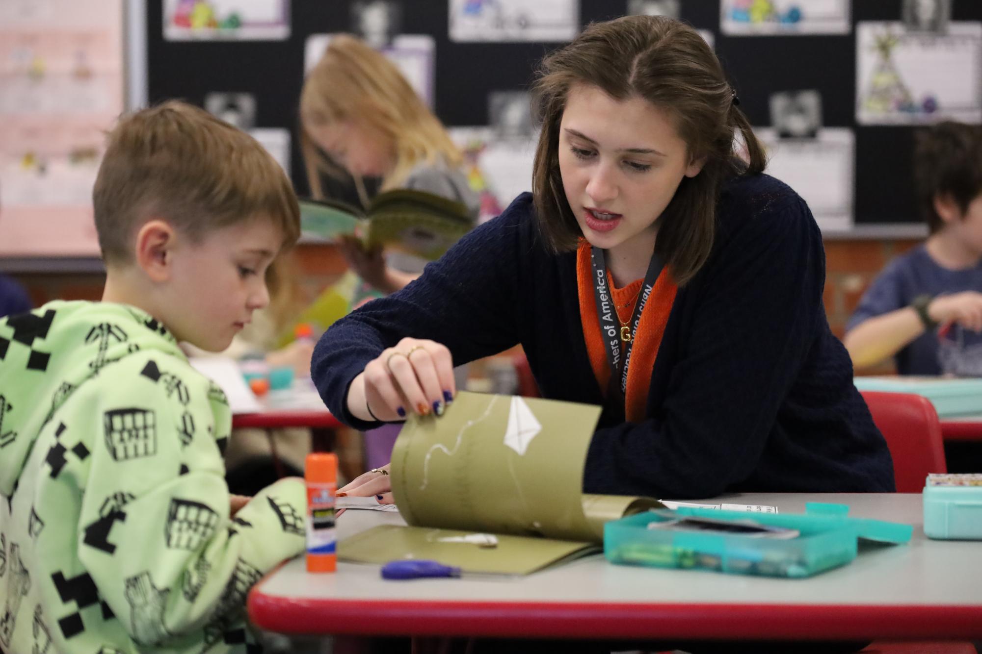 Turing the page Gracie King (12) helps a first grader create a storyboard using the events in the book "Gilberto and the Wind." 